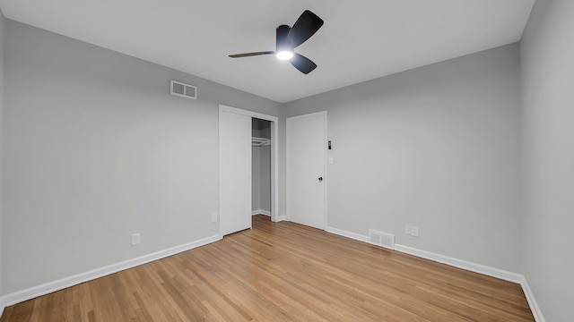 unfurnished bedroom with ceiling fan, a closet, and light hardwood / wood-style flooring