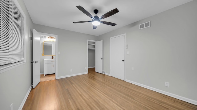 unfurnished bedroom with ceiling fan, a closet, ensuite bathroom, and light hardwood / wood-style flooring