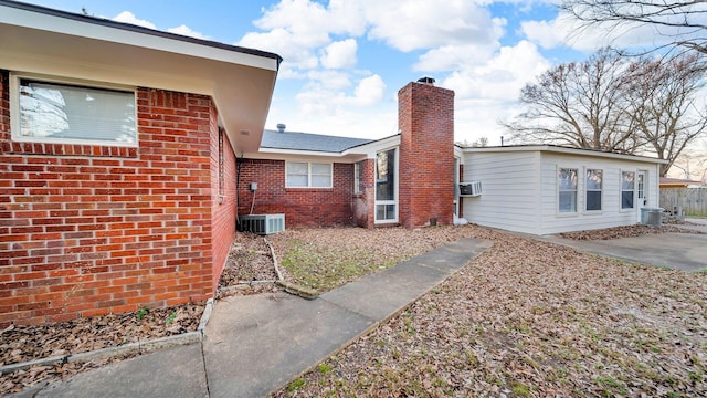 view of side of home featuring cooling unit, a patio area, and central AC