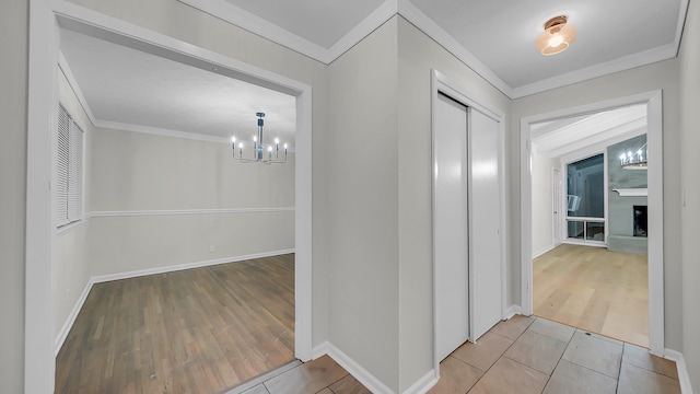 hallway featuring ornamental molding, a notable chandelier, and light tile patterned flooring