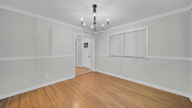 unfurnished dining area featuring ornamental molding, light hardwood / wood-style floors, and a notable chandelier