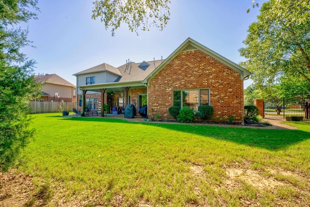 rear view of property with a patio and a lawn