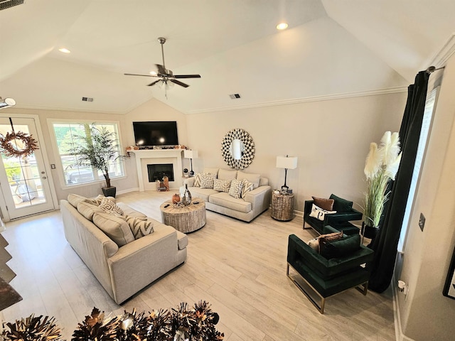 living room featuring light hardwood / wood-style flooring, vaulted ceiling, ceiling fan, and ornamental molding