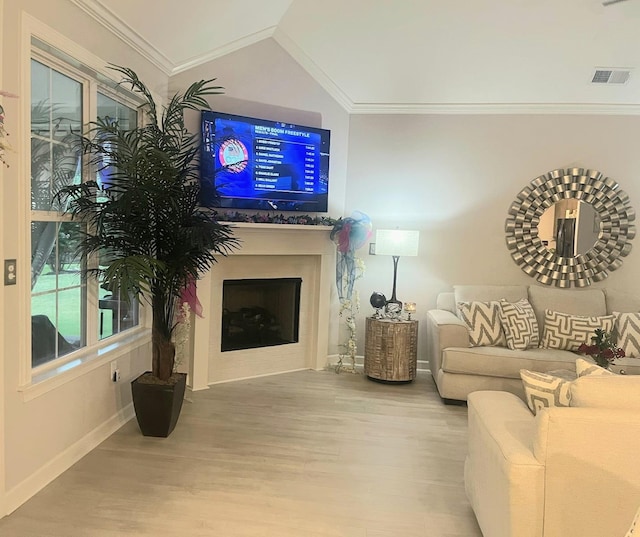 living room with wood-type flooring, vaulted ceiling, and crown molding