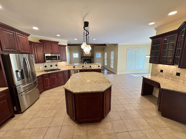 kitchen with pendant lighting, decorative backsplash, a center island, and stainless steel appliances