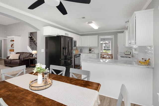 dining room featuring ceiling fan, light wood-type flooring, ornamental molding, and sink