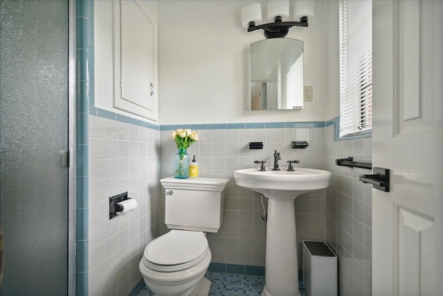 bathroom featuring tile patterned flooring, toilet, and tile walls