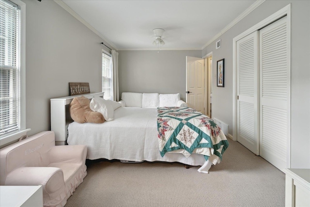 bedroom featuring carpet, a closet, ceiling fan, and crown molding