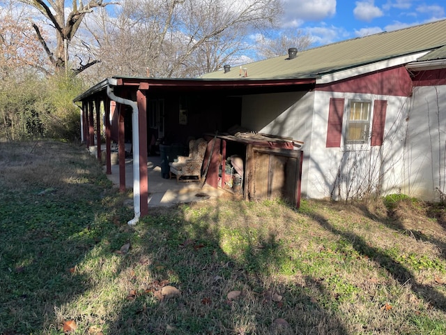 view of side of property featuring a patio area and a yard