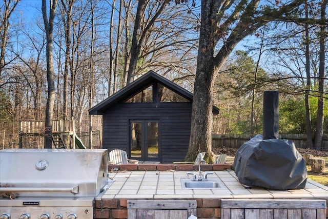 view of patio / terrace with a playground, area for grilling, french doors, and sink