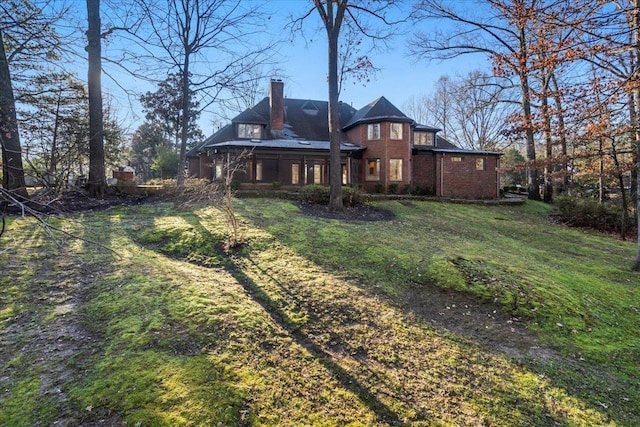 rear view of house featuring a lawn