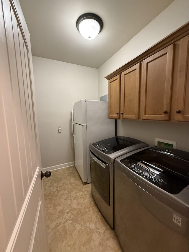 clothes washing area featuring cabinets and washing machine and dryer