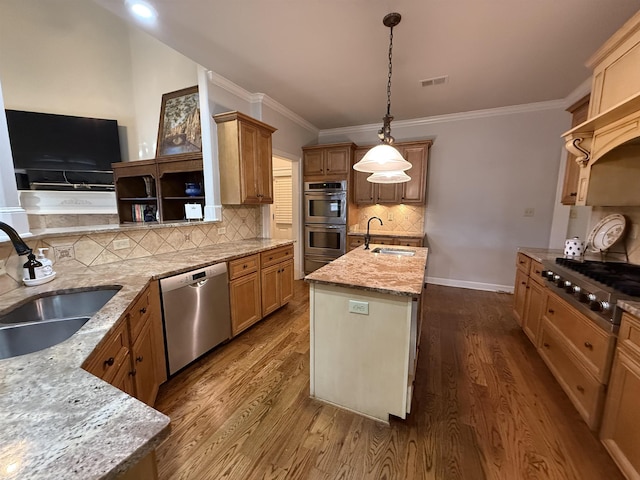 kitchen featuring light stone counters, sink, a center island with sink, and appliances with stainless steel finishes