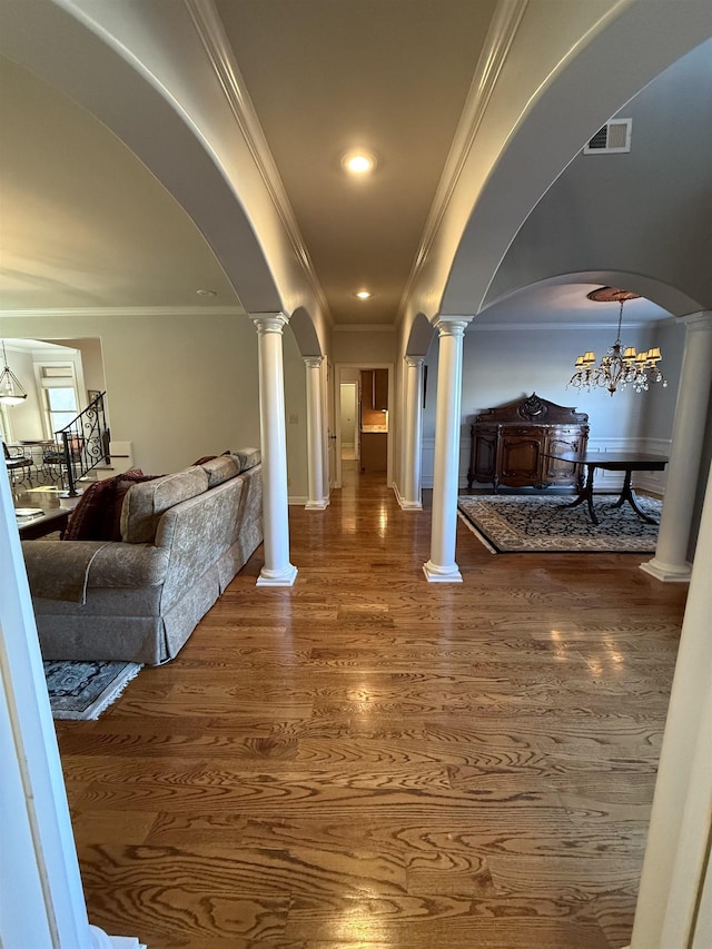 corridor with ornamental molding, dark wood-type flooring, and a notable chandelier