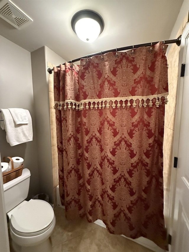 bathroom with tile patterned floors, shower / bath combo, and toilet