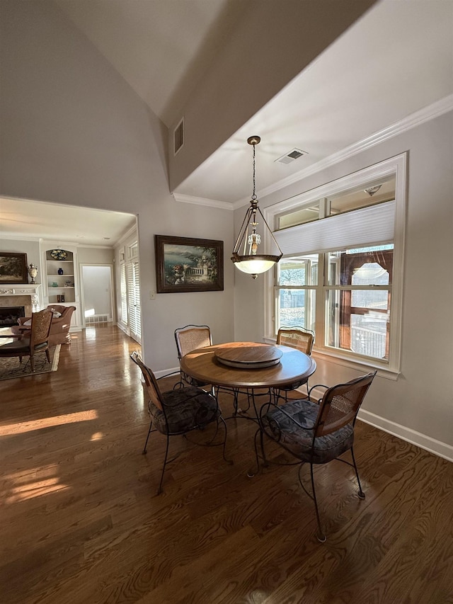 dining area with built in shelves, lofted ceiling, and dark wood-type flooring