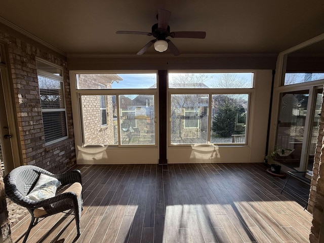 unfurnished sunroom featuring ceiling fan