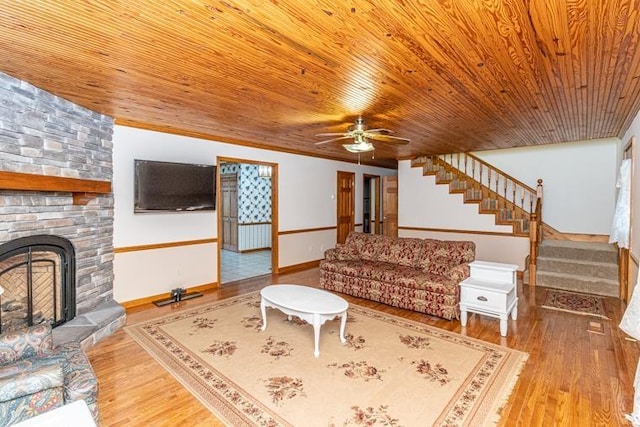 living room with ceiling fan, wooden ceiling, a fireplace, and light hardwood / wood-style flooring