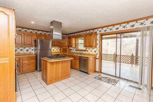 kitchen with stainless steel appliances, a kitchen island, a textured ceiling, island range hood, and light tile patterned floors