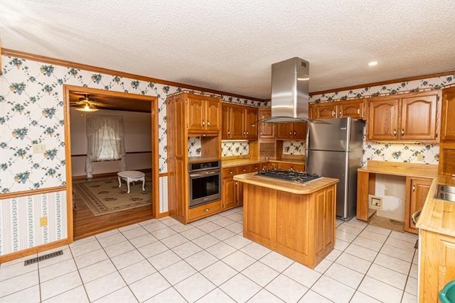 kitchen featuring a center island, stainless steel appliances, island exhaust hood, crown molding, and a textured ceiling