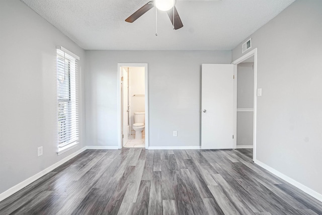 unfurnished bedroom with hardwood / wood-style floors, ceiling fan, a textured ceiling, and connected bathroom