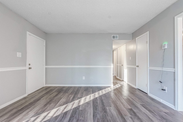 spare room with wood-type flooring and a textured ceiling