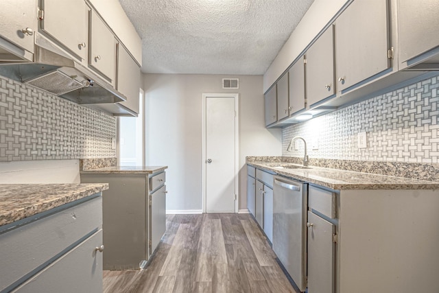 kitchen featuring tasteful backsplash, gray cabinetry, a textured ceiling, sink, and dishwasher