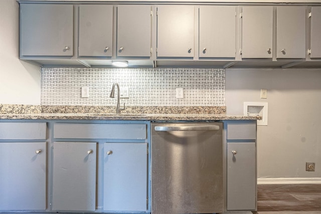 kitchen featuring stainless steel dishwasher, gray cabinets, and tasteful backsplash