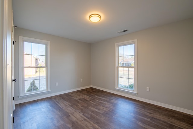 empty room featuring dark hardwood / wood-style floors and plenty of natural light