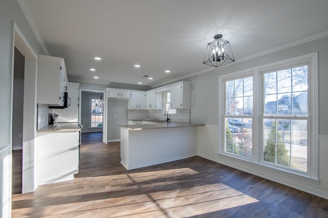 kitchen with pendant lighting, white cabinets, sink, a notable chandelier, and kitchen peninsula