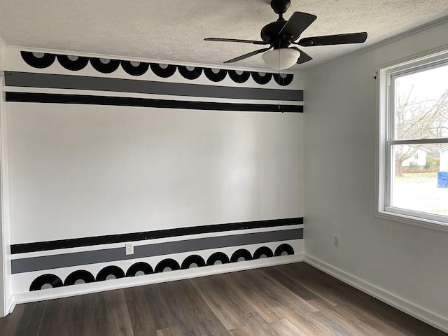 unfurnished room featuring ceiling fan, dark hardwood / wood-style floors, plenty of natural light, and a textured ceiling