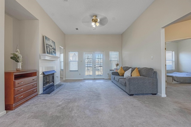 carpeted living room with french doors and ceiling fan