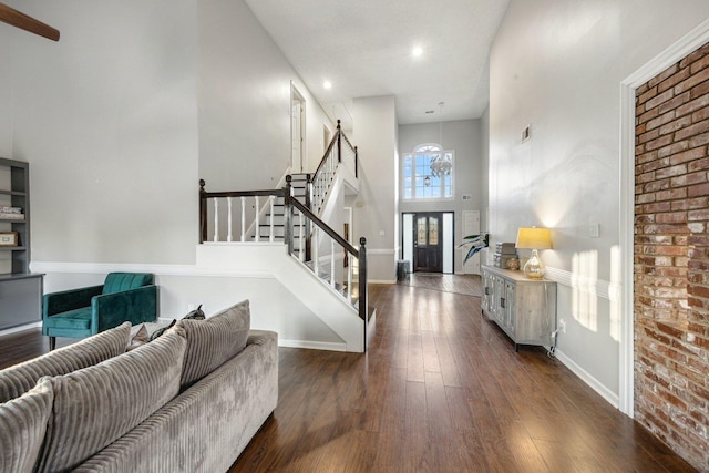 foyer entrance featuring dark hardwood / wood-style floors and a towering ceiling