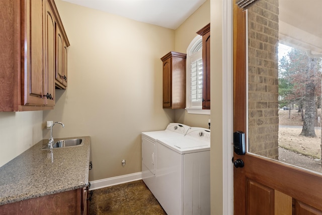 clothes washing area with washer and dryer, sink, and cabinets