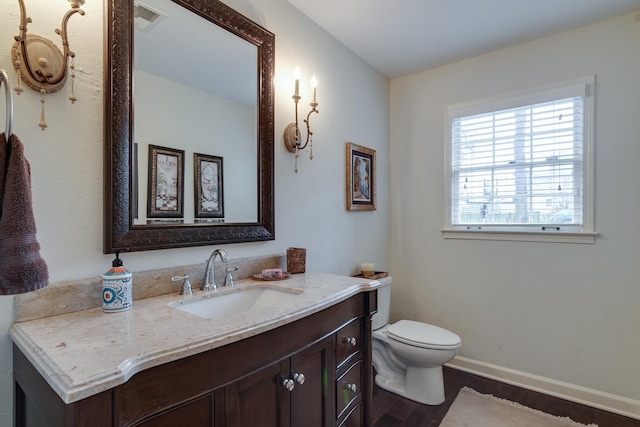 bathroom featuring vanity, toilet, and wood-type flooring