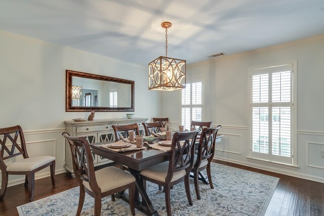 dining room with plenty of natural light, crown molding, dark wood-type flooring, and an inviting chandelier