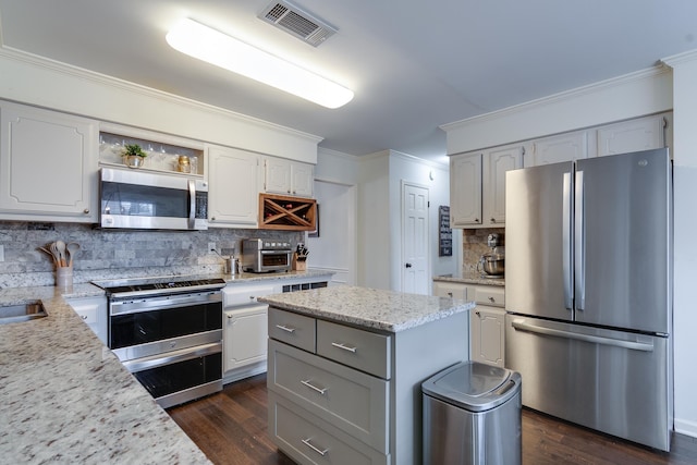 kitchen with tasteful backsplash, a center island, white cabinets, and appliances with stainless steel finishes