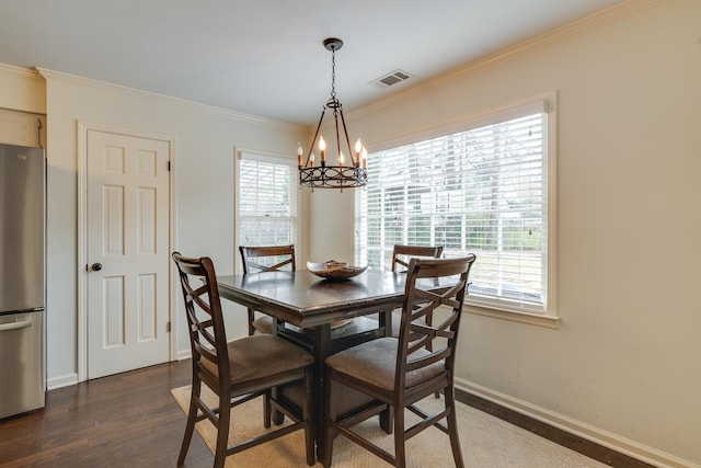 dining room with a chandelier, dark hardwood / wood-style flooring, and ornamental molding