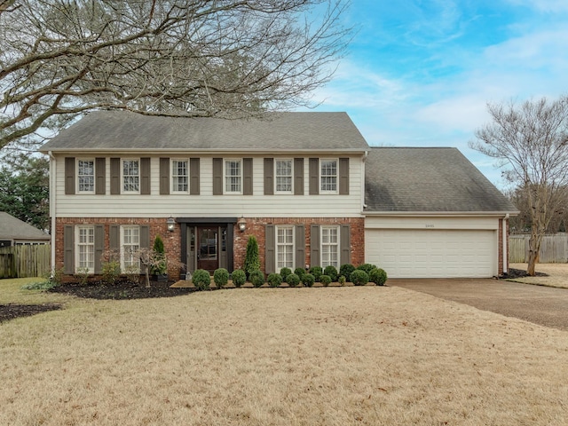 colonial home with a front yard and a garage