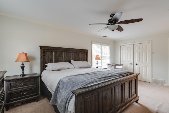 bedroom with a closet, light colored carpet, ceiling fan, and crown molding