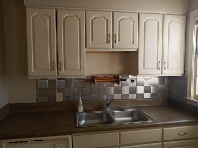 kitchen featuring dishwasher, white cabinetry, sink, and tasteful backsplash