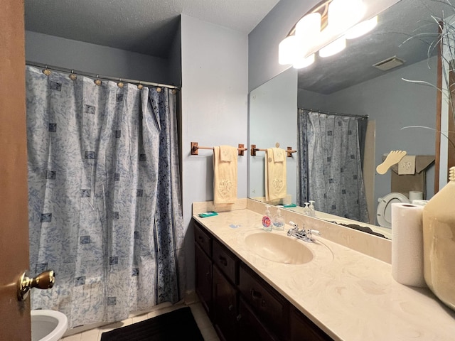 bathroom with tile patterned floors, vanity, toilet, and a textured ceiling