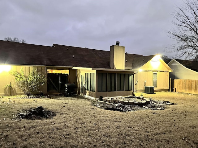 rear view of property with central AC and a sunroom