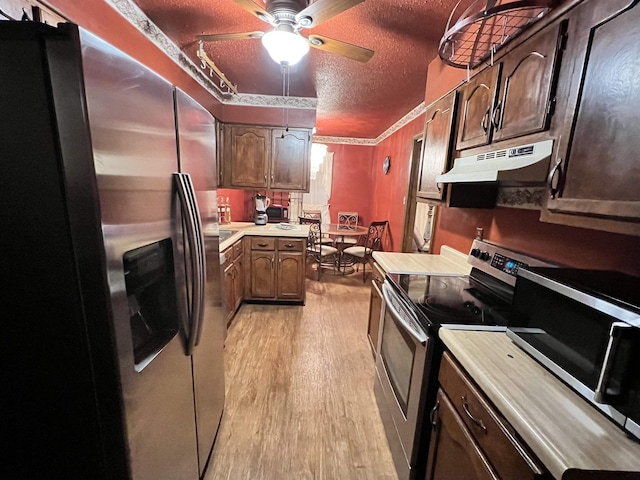 kitchen featuring light hardwood / wood-style floors, dark brown cabinetry, a textured ceiling, and appliances with stainless steel finishes