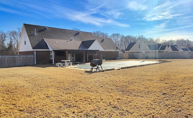 rear view of house with a patio area and a lawn