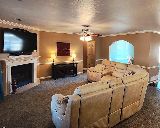 living room with ornamental molding, carpet flooring, ceiling fan, and a textured ceiling