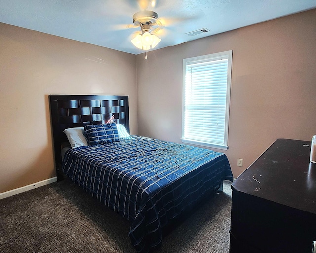 bedroom with ceiling fan and dark carpet