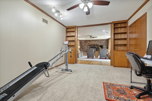 carpeted office featuring ceiling fan, ornamental molding, and a textured ceiling