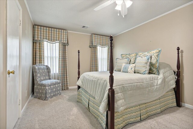 carpeted bedroom with ceiling fan and crown molding