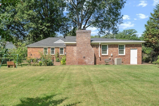 rear view of property featuring a yard and cooling unit